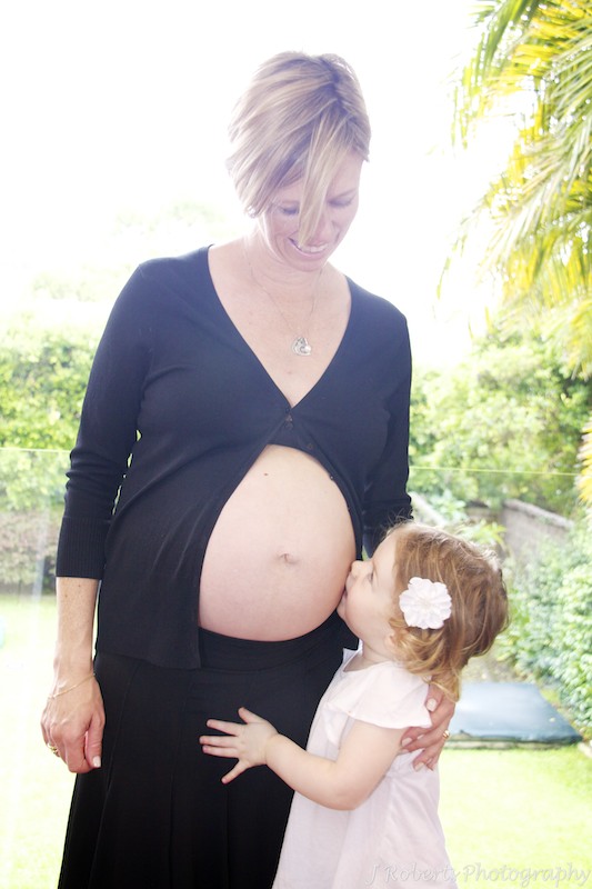 Big sister kissing pregnant belly - pregnancy portraits sydney